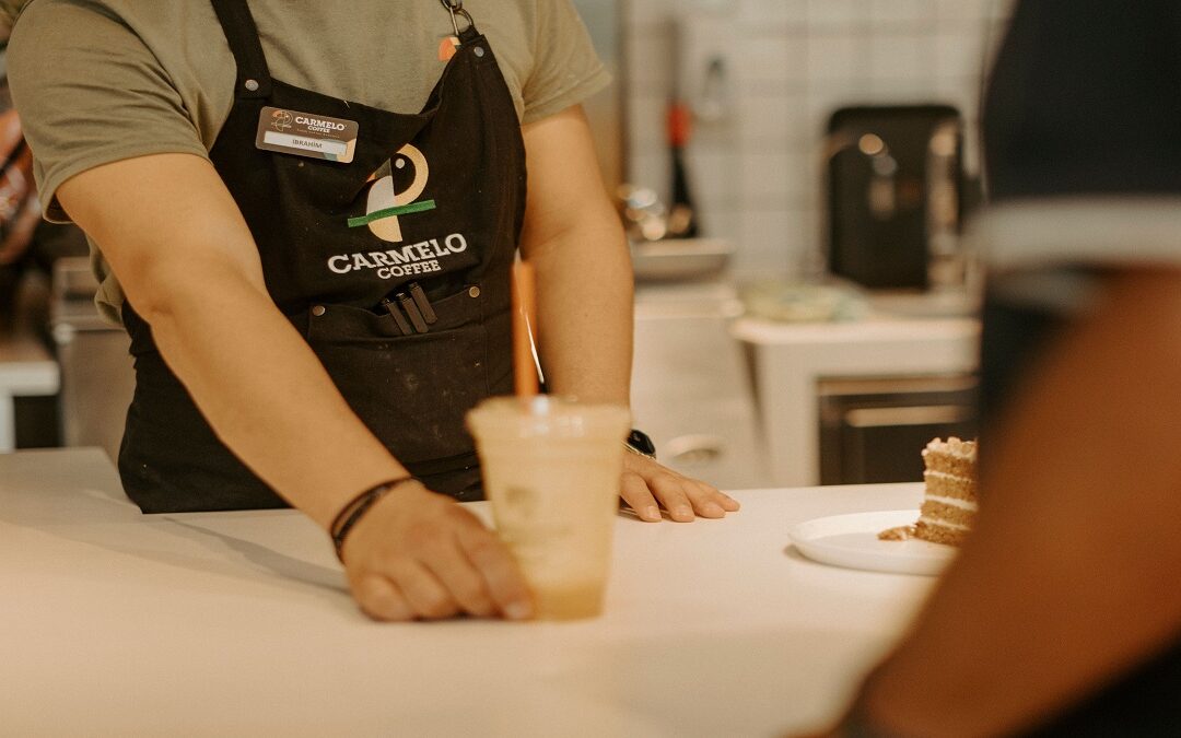 Barista serving takeaway coffee at a café counter