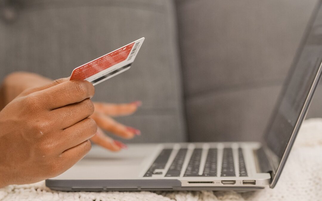 Person paying their Self Assessment tax bill online to HMRC with a laptop and bank card