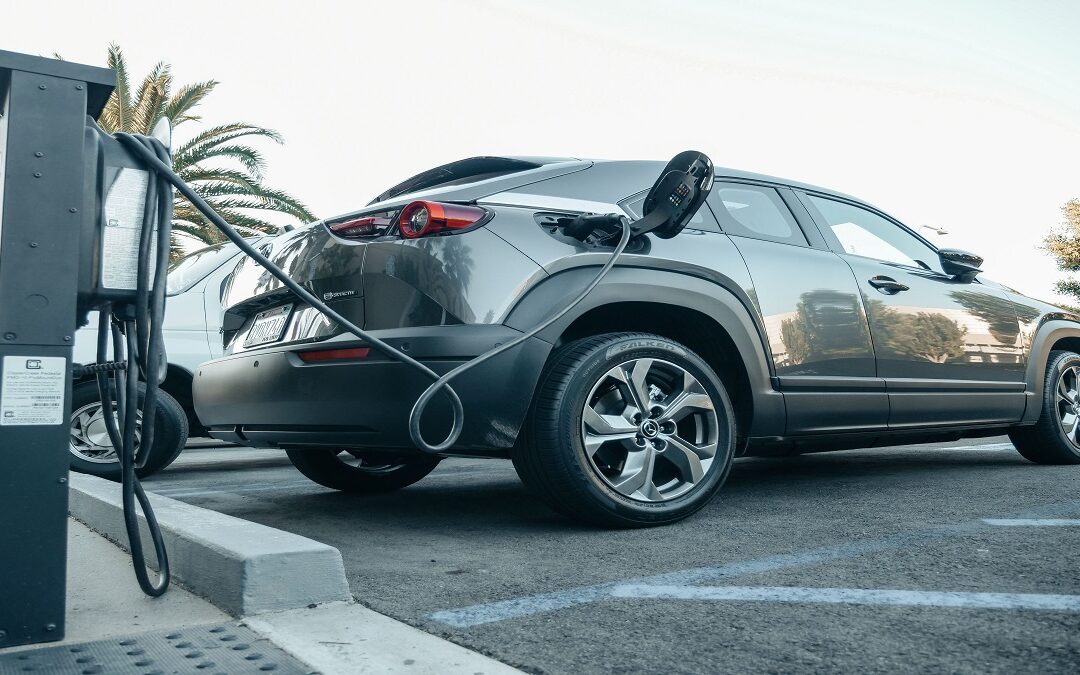 HMRC electric car mileage allowance: driver recording business miles from an electric car dashboard